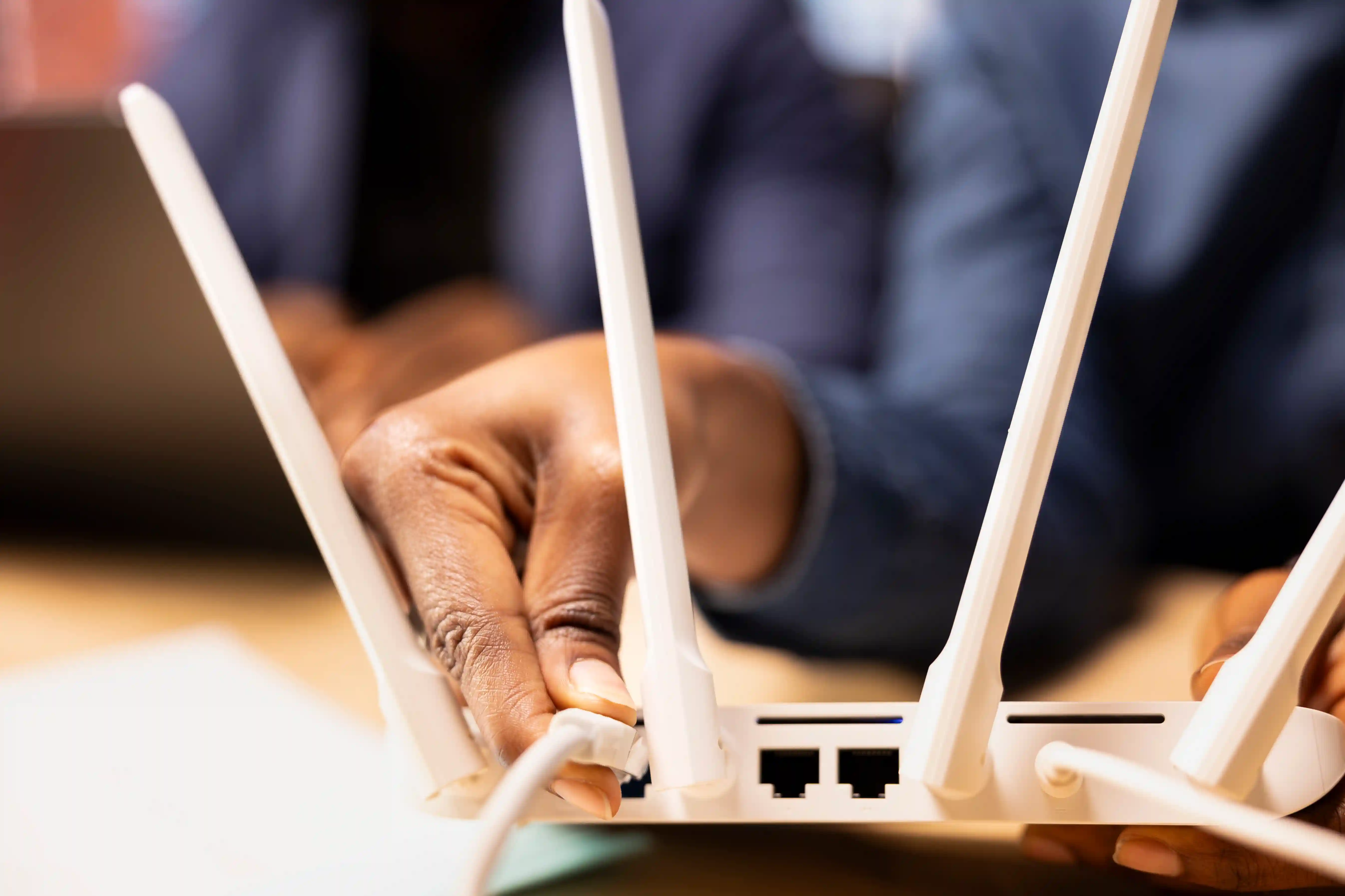 Technician connecting a cable to a router at the counter